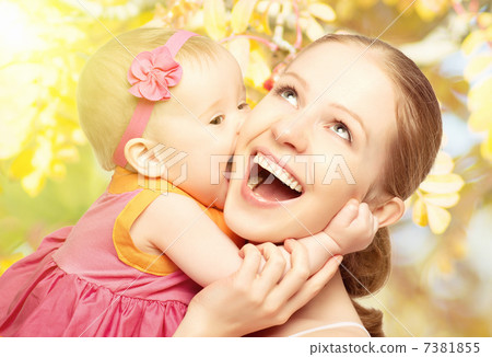 Happy cheerful family. Mother and baby kissing in nature outdoor Happy cheerful family. Mother and baby kissing in nature outdoor 7381855