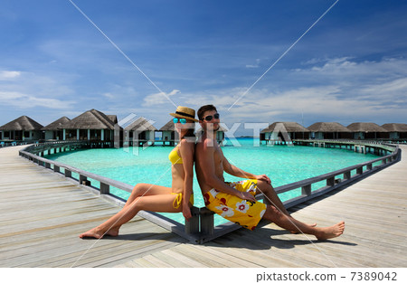 Couple on a beach jetty at Maldives Couple on a beach jetty at Maldives 7389042