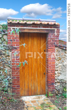 Wooden door in an old stone fence 7389718