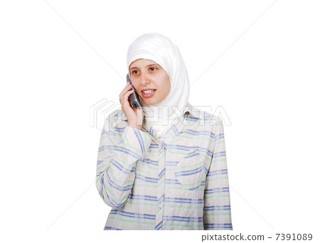 A young muslim woman in traditional clothes isolated speaking on phone A young muslim woman in traditional clothes isolated speaking on phone 7391089