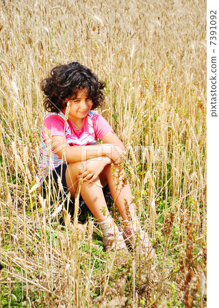 A little pretty girl siting on wheat field A little pretty girl siting on wheat field 7391092