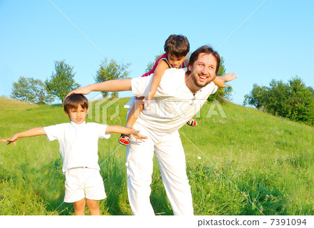 Young father in white with boys on beautiful meadow Young father in white with boys on beautiful meadow 7391094