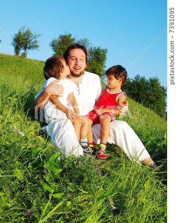 Young father in white with children on beautiful meadow Young father in white with children on beautiful meadow 7391095
