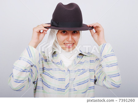 A young muslim woman in traditional clothes with a hat A young muslim woman in traditional clothes with a hat 7391260
