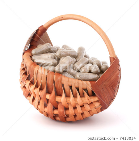 Herbal drug capsules in wicker basket. Alternative medicine conc Herbal drug capsules in wicker basket. Alternative medicine conc 7413034