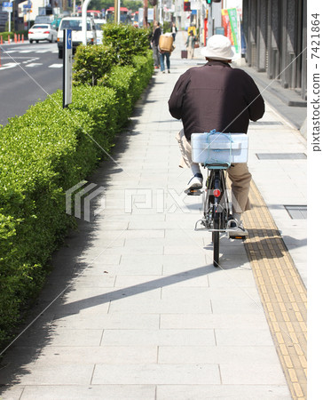 An old man riding a bicycle An old man riding a bicycle 7421864