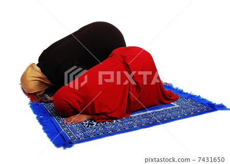 Young muslim female in traditional clothes praying with little girl 7431650