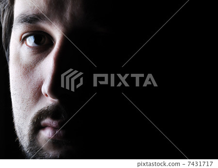 Low-key portrait - half face - sad and angry looking man Low-key portrait - half face - sad and angry looking man 7431717