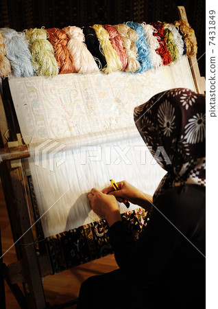 Woman working at the loom. Oriental Muslim national crafts. Focus on the fabric. Woman working at the loom. Oriental Muslim national crafts. Focus on the fabric. 7431849