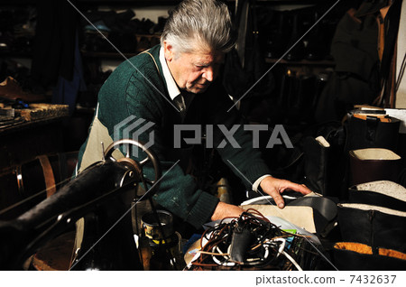 Senior man working with old machine in his own workshop 7432637