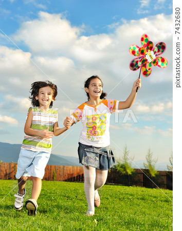 Fantastic scene of happy children running and playing carefreely on green meadow in nature Fantastic scene of happy children running and playing carefreely on green meadow in nature 7432680