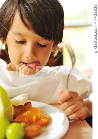Real enjoying food, cute kid with finger in his mouth 7432839