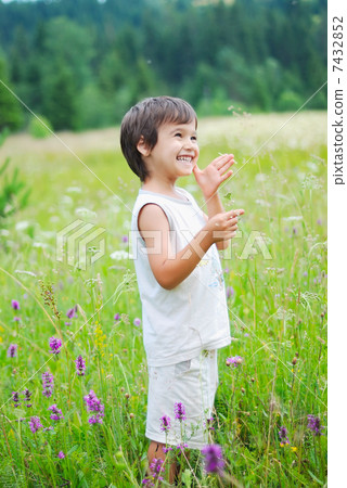 Cute little boy on green grass in nature 7432852