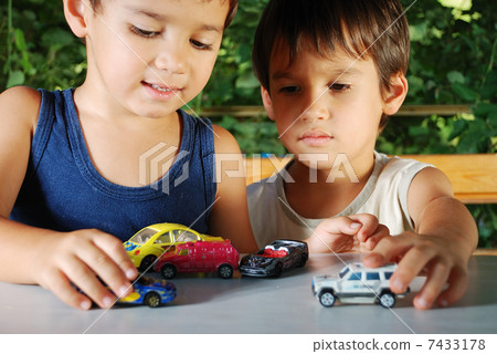 Children playing with cars toys outdoor in summer time Children playing with cars toys outdoor in summer time 7433178