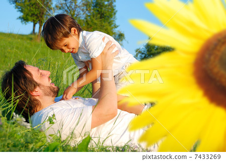 Happy childhool on green meadow, behind sunflower 7433269