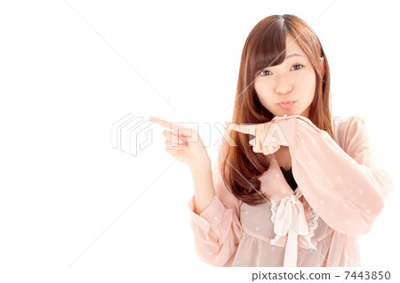 A cute girl pointing sideways looking happily 7443850