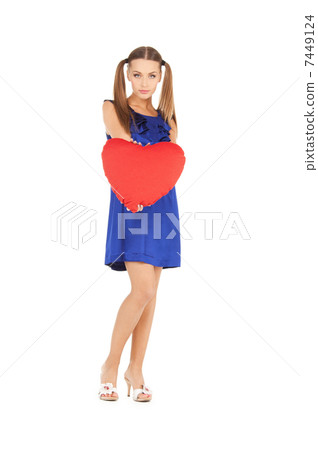 lovely woman with red heart-shaped pillow 7449124