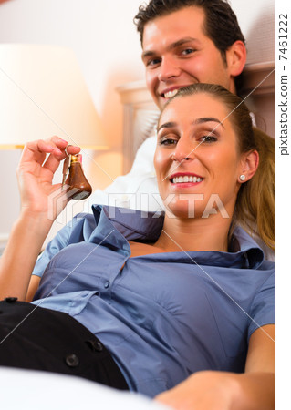 Young couple lying on bed in hotel room Young couple lying on bed in hotel room 7461222