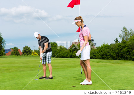 Young sportive couple playing golf on a course 7461249