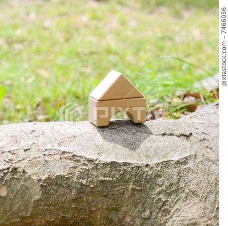 A house made of building blocks placed on top of a log A house made of building blocks placed on top of a log 7466056