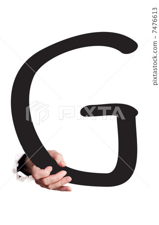 Hand breaking paper surface holding letter 'G' 7476613