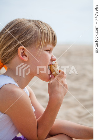 Young girl eating ice cream on beach Young girl eating ice cream on beach 7478968