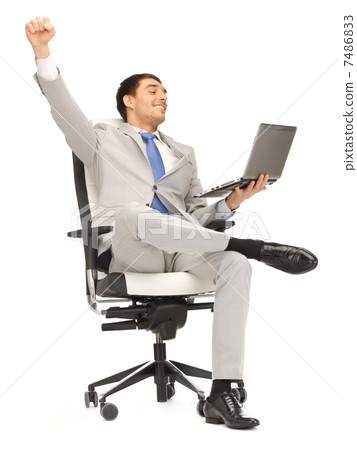 young businessman sitting in chair with laptop 7486833