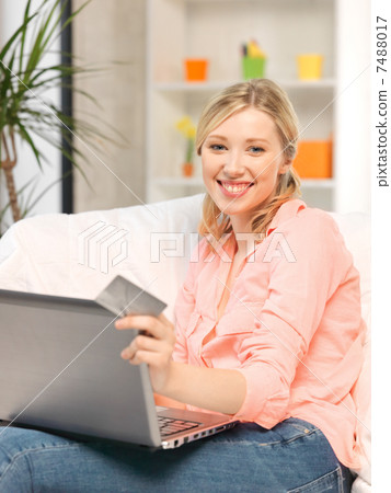 happy woman with laptop computer and credit card 7488017