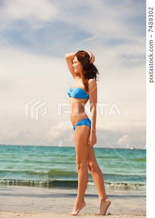 happy smiling woman walking on the beach 7489302