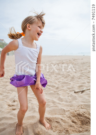 Young girl playing on beach 7491119