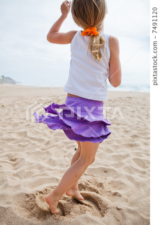 Young girl playing on beach 7491120