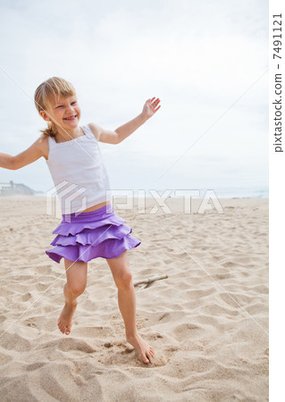 Young girl playing on beach 7491121