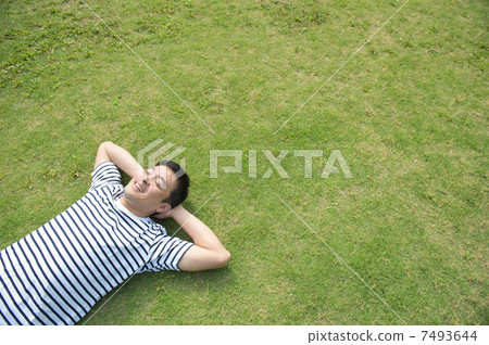 一個男人躺在草坪上 一個男人躺在草坪上 7493644