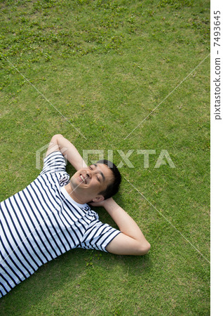 一個男人躺在草坪上 一個男人躺在草坪上 7493645
