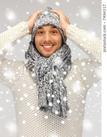 handsome man in warm sweater, hat and scarf 7494317