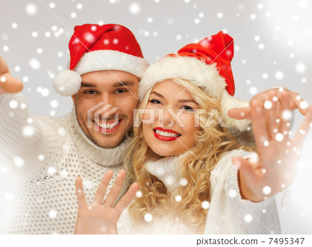 family couple in sweaters and santas hats 7495347