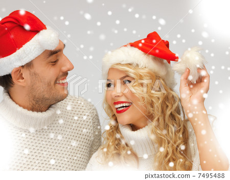 family couple in sweaters and santas hats 7495488
