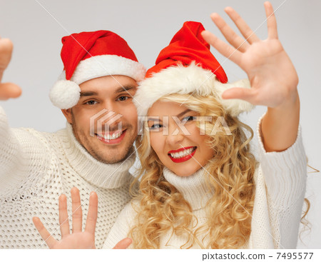 family couple in sweaters and santas hats family couple in sweaters and santas hats 7495577