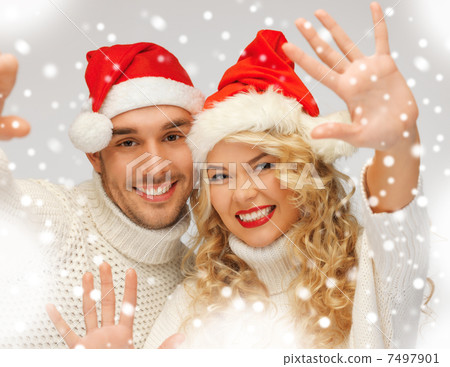 family couple in sweaters and santas hats 7497901