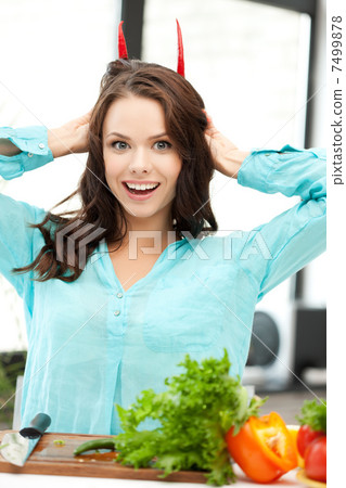 beautiful woman in the kitchen cutting vegetables 7499878