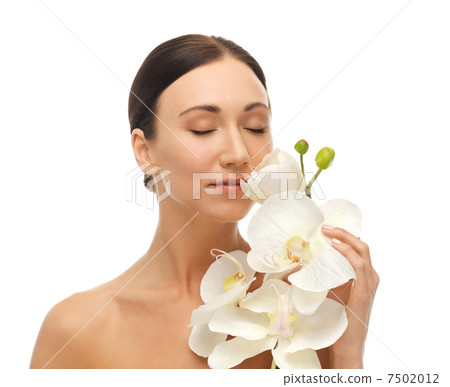 woman smelling white orchid flower woman smelling white orchid flower 7502012
