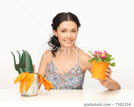 housewife with flower in pot and gardening set 7502356