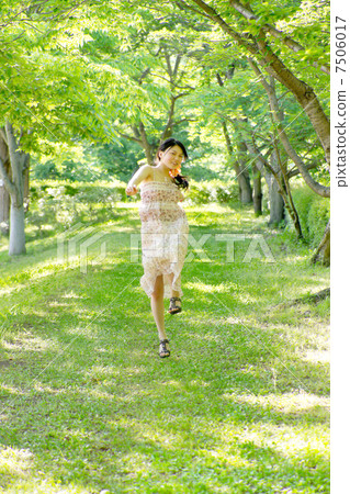 A girl who skips fun freshly in the green and refreshing summer sunshine 7506017