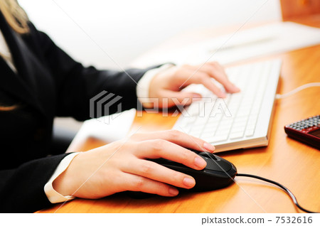 Female hands typing on a keyboard and holding mouse 7532616