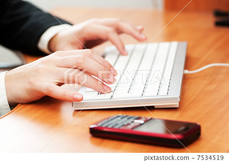 Female hands typing on a keyboard Female hands typing on a keyboard 7534519
