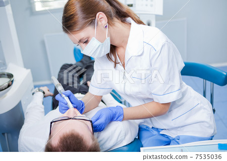 Young female dentist working in her office. Young female dentist working in her office. 7535036