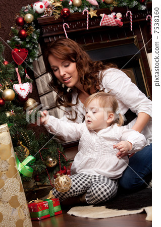 Happy mother decorating christmas tree with her baby 7538160