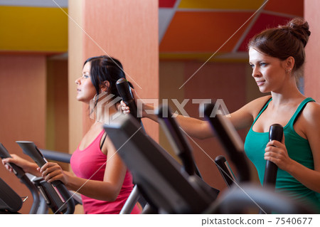 Young women in gym on stepper machine 7540677