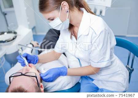 Young female dentist working in her office. Young female dentist working in her office. 7541967