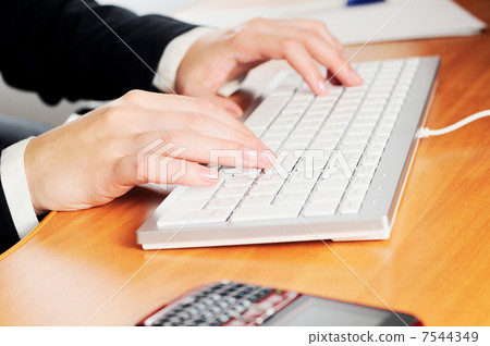 Female hands typing on a keyboard 7544349